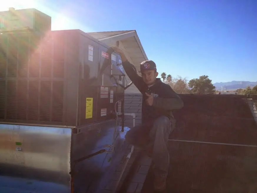 HVAC technician performing Heat Pump Repair on a rooftop unit in Baraboo